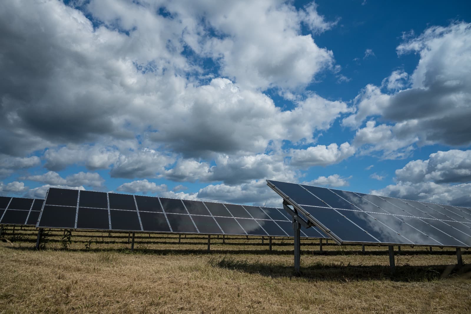 Painéis solares sob céu nublado e carregado, remetendo às chuvas fortes que voltaram ao RS